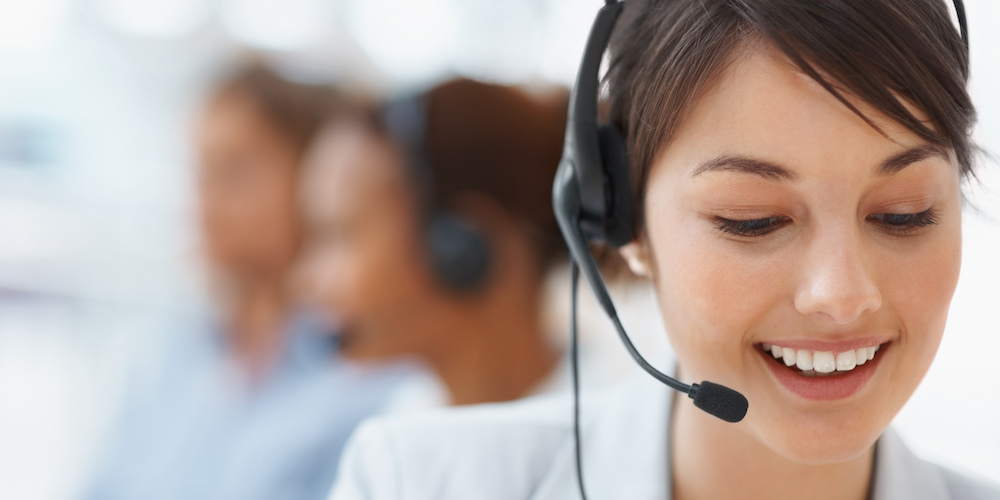 Beautiful customer representative with headset smiling during a telephone conversation